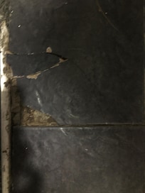 Cracked tiles in bathroom that could cut feet.