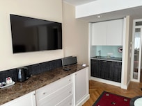 Full kitchen with cooktop, microwave, fridge, dishwasher, cutlery and dishes.