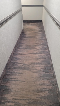 Dark brown carpet in common areas managed to look worn and dirty.
