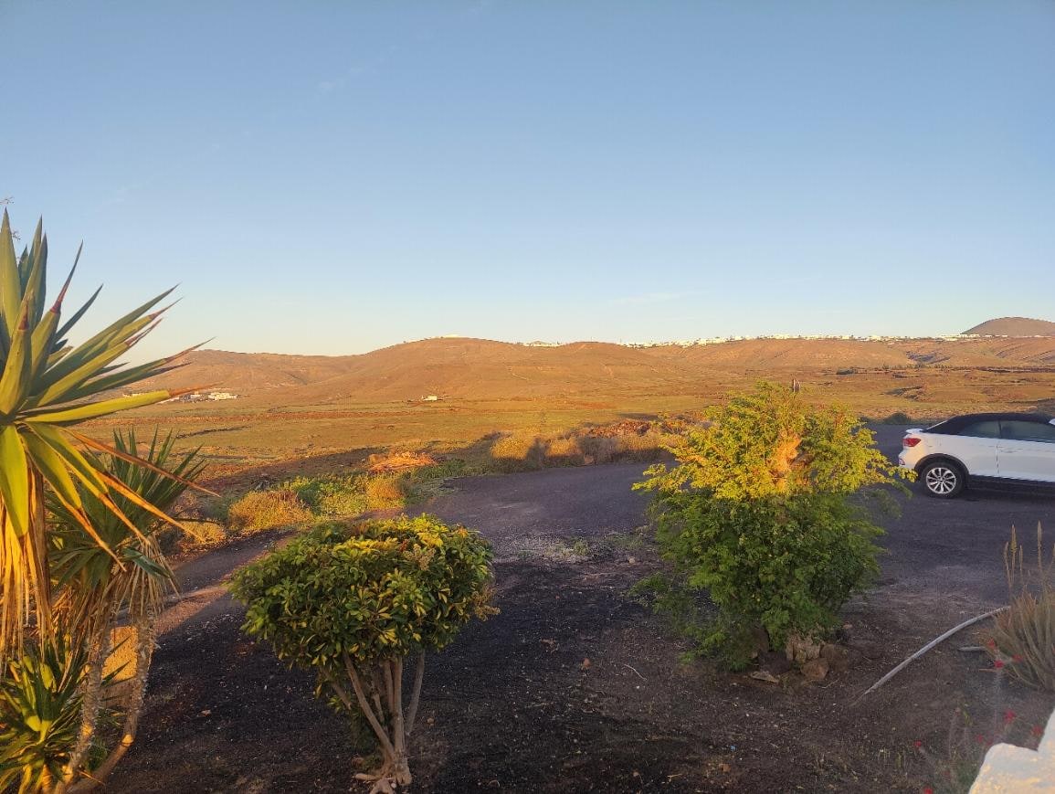 Blick über den kleinen Parkplatz vor dem Eingang nach Westen