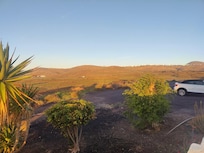 Blick über den kleinen Parkplatz vor dem Eingang nach Westen