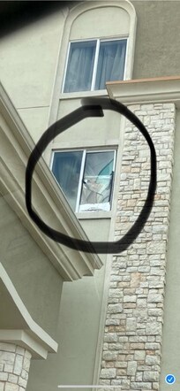 Broken window with stuff hanging from it .