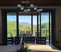 Diningroom with outdoor balcony overlooking the tree covered mountains.