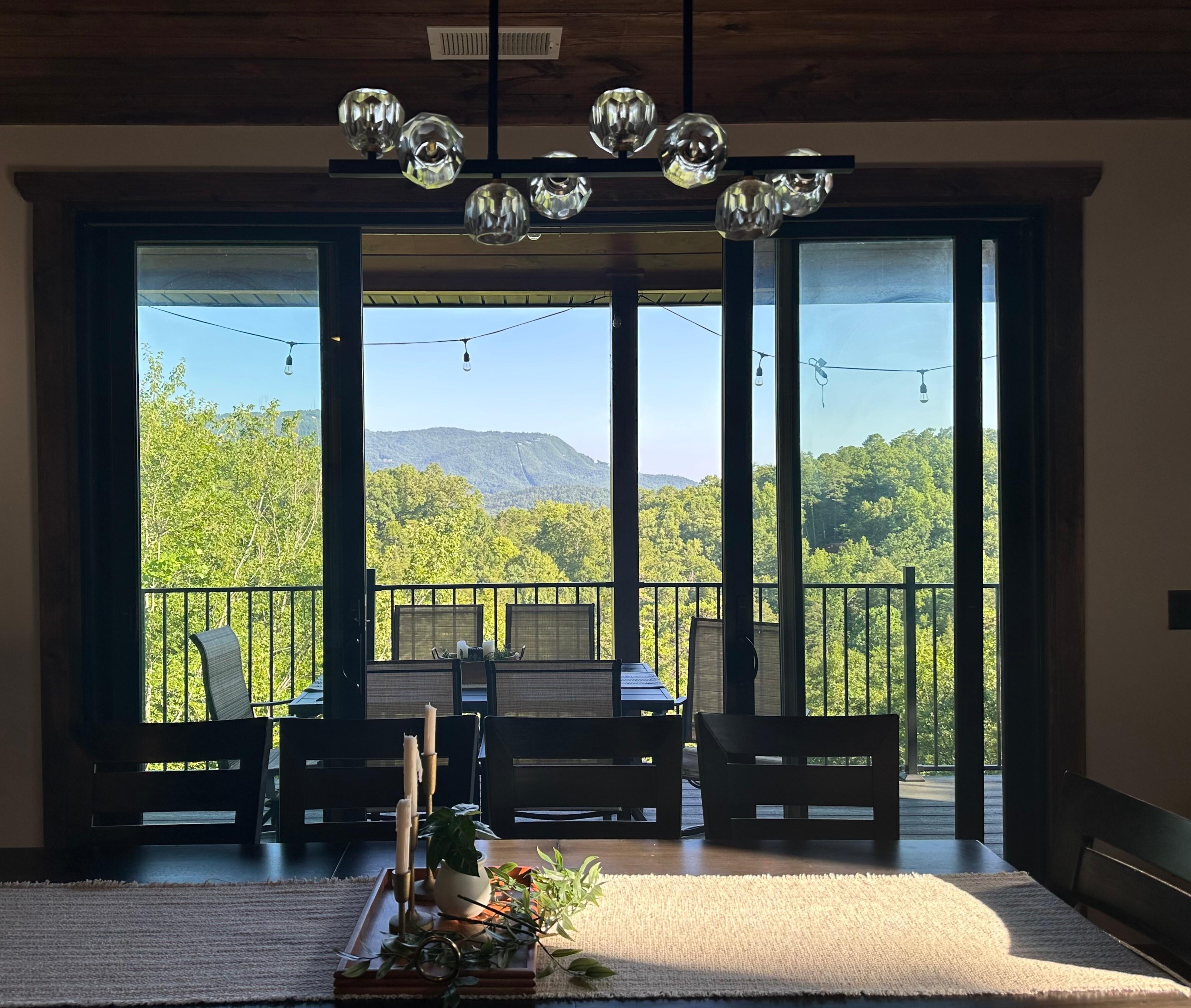 Diningroom with outdoor balcony overlooking the tree covered mountains. 