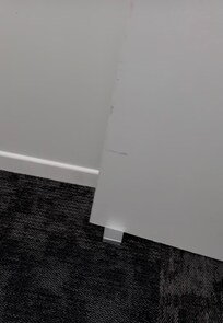 Fire door wedged open on ground floor near bottom of stairs and lift