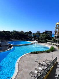 The pool area from the balcony of the room with a little peak of the ocean in the background.