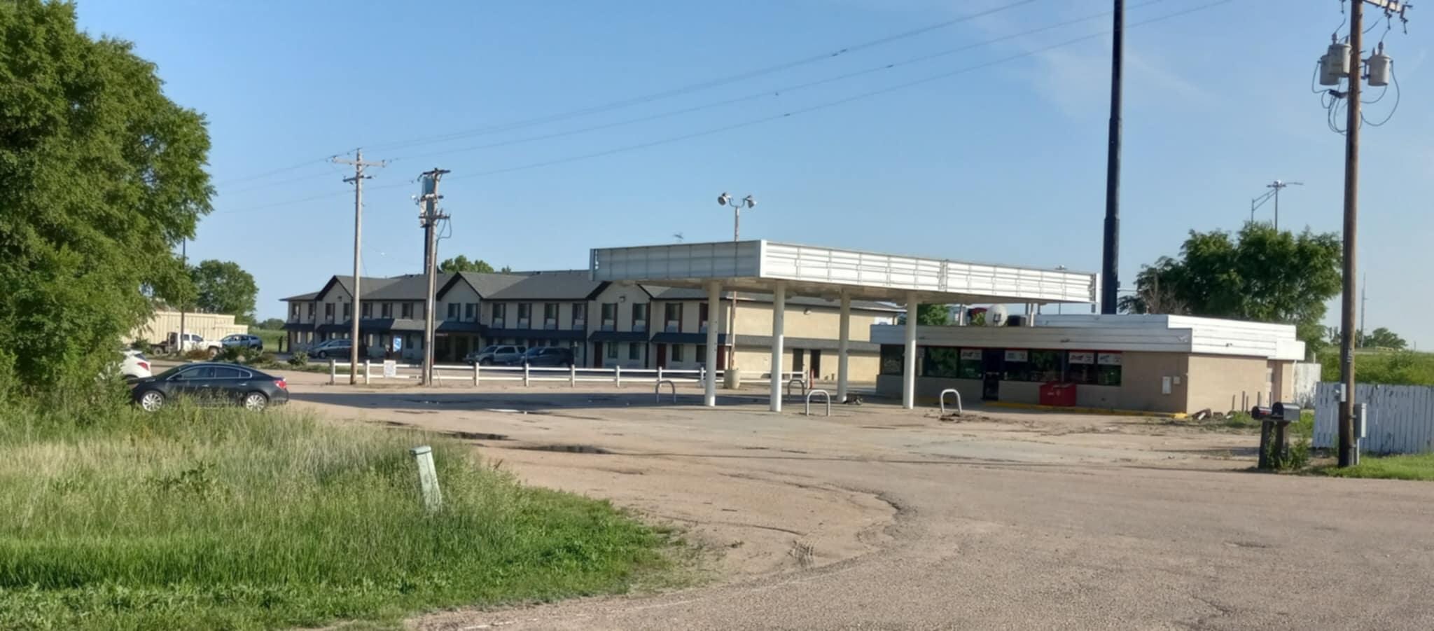 View of the abandoned gas station next to our hotel whose signage consisted of a vinyl sign tied to a post out front.