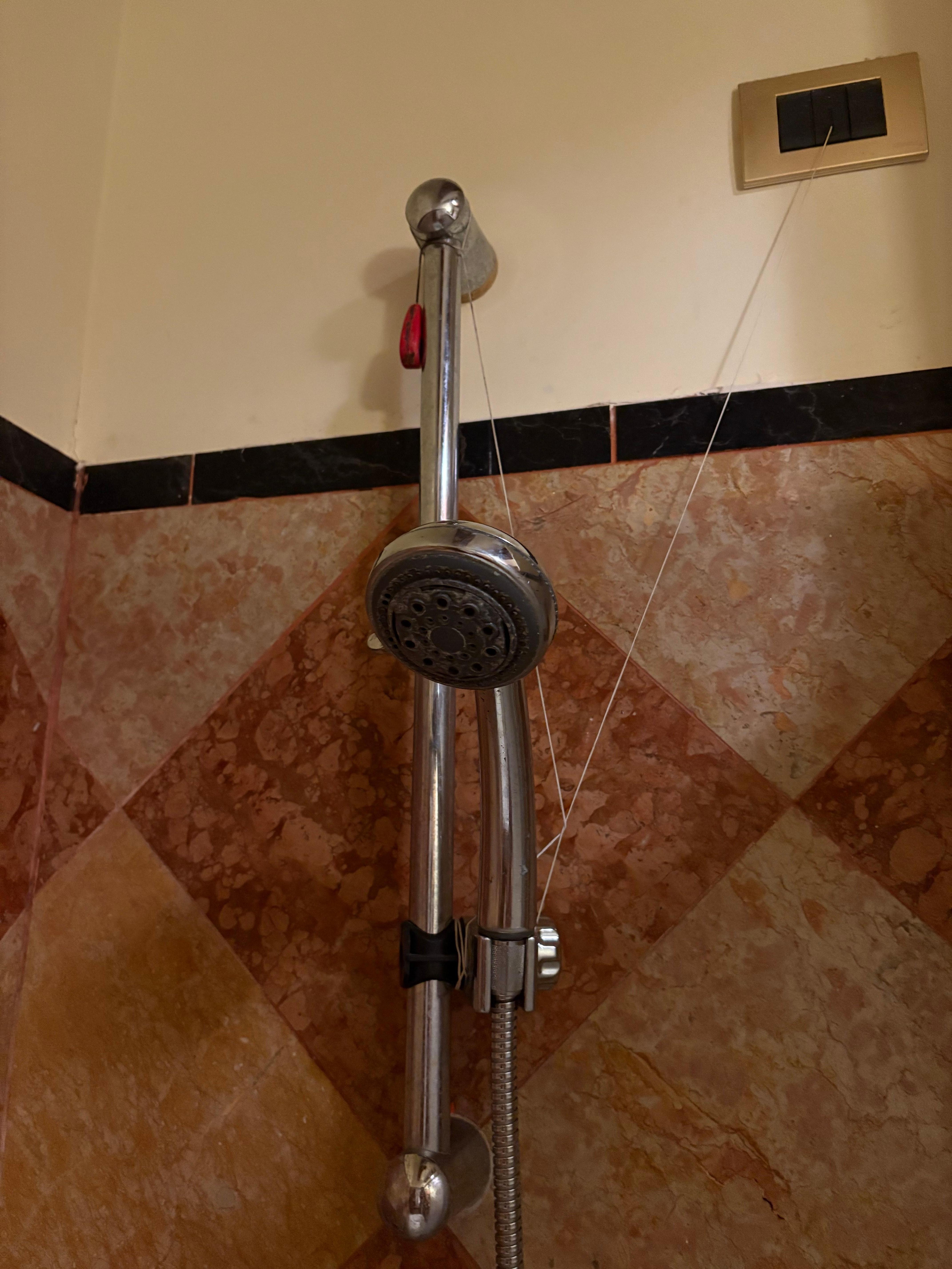 Pommeau de douche cassé et rafistolé de manière médiocre 