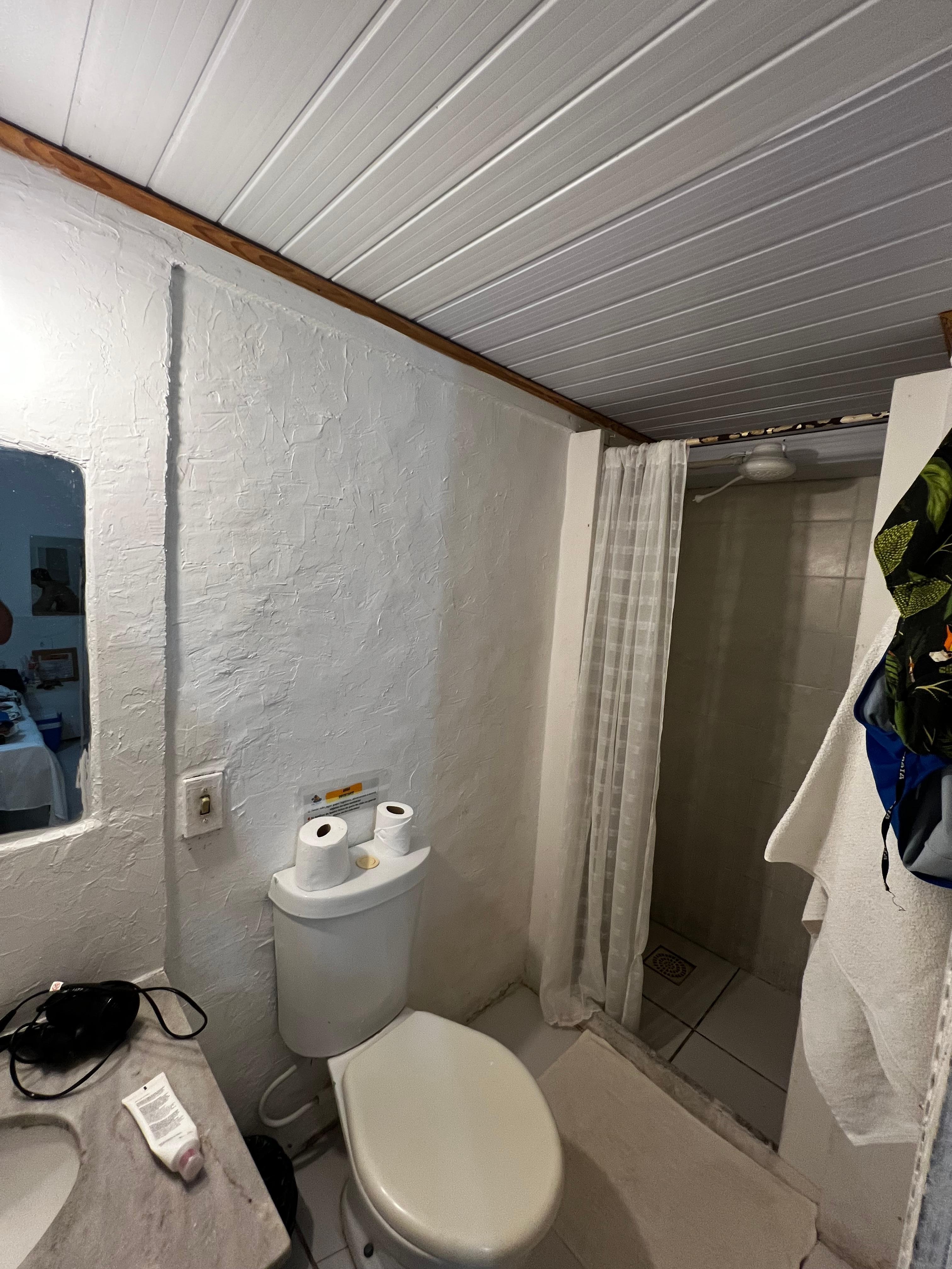 Banheiro teto baixo, sem box, sem ventilação. 