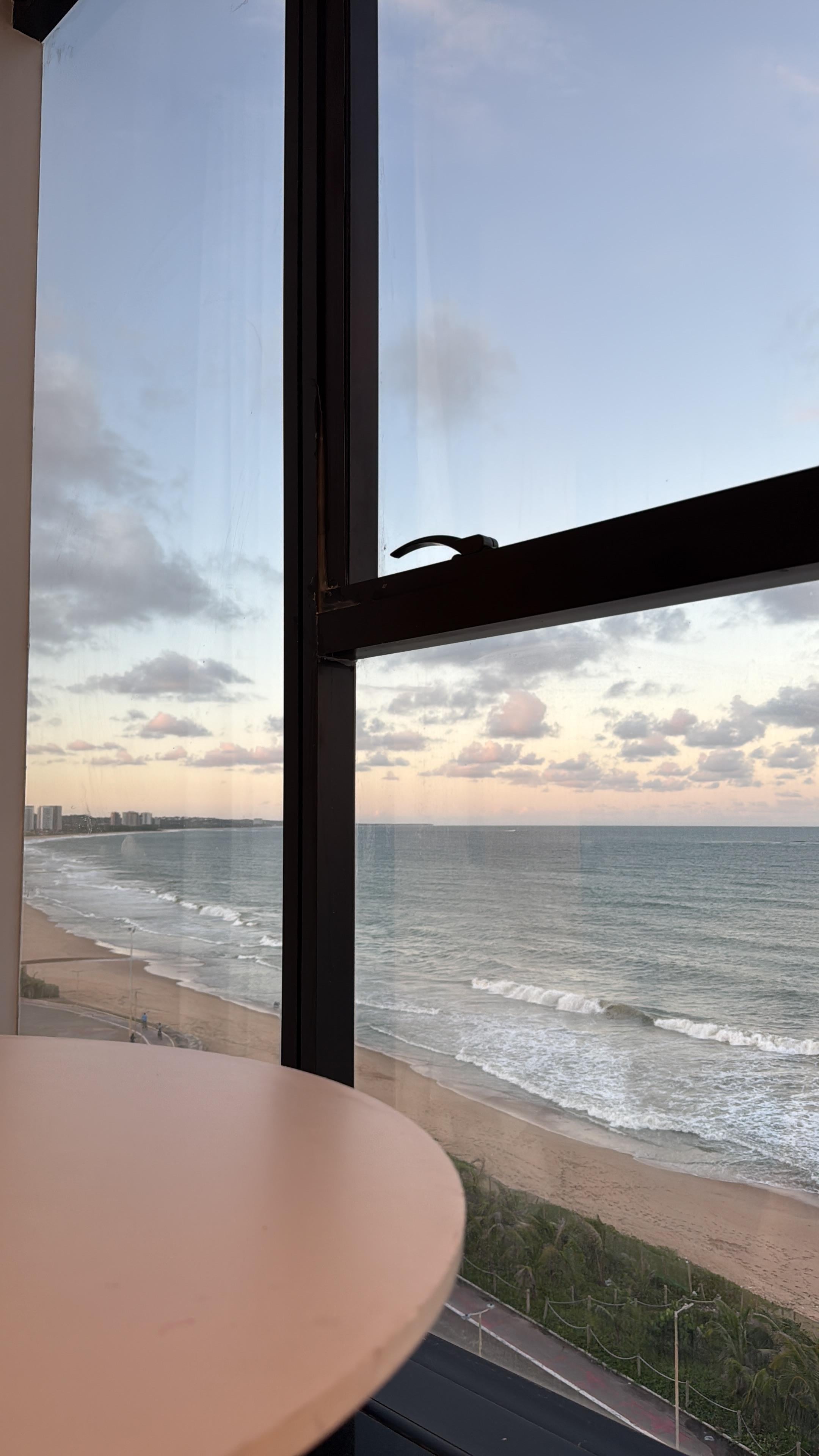 Vista do quarto que possui mesa e cadeira porém não tem serviço de quarto