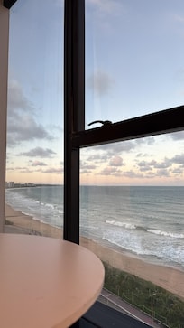 Vista do quarto que possui mesa e cadeira porém não tem serviço de quarto