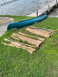 Wooden planks strewn in the yard and unattached planks on the dock.