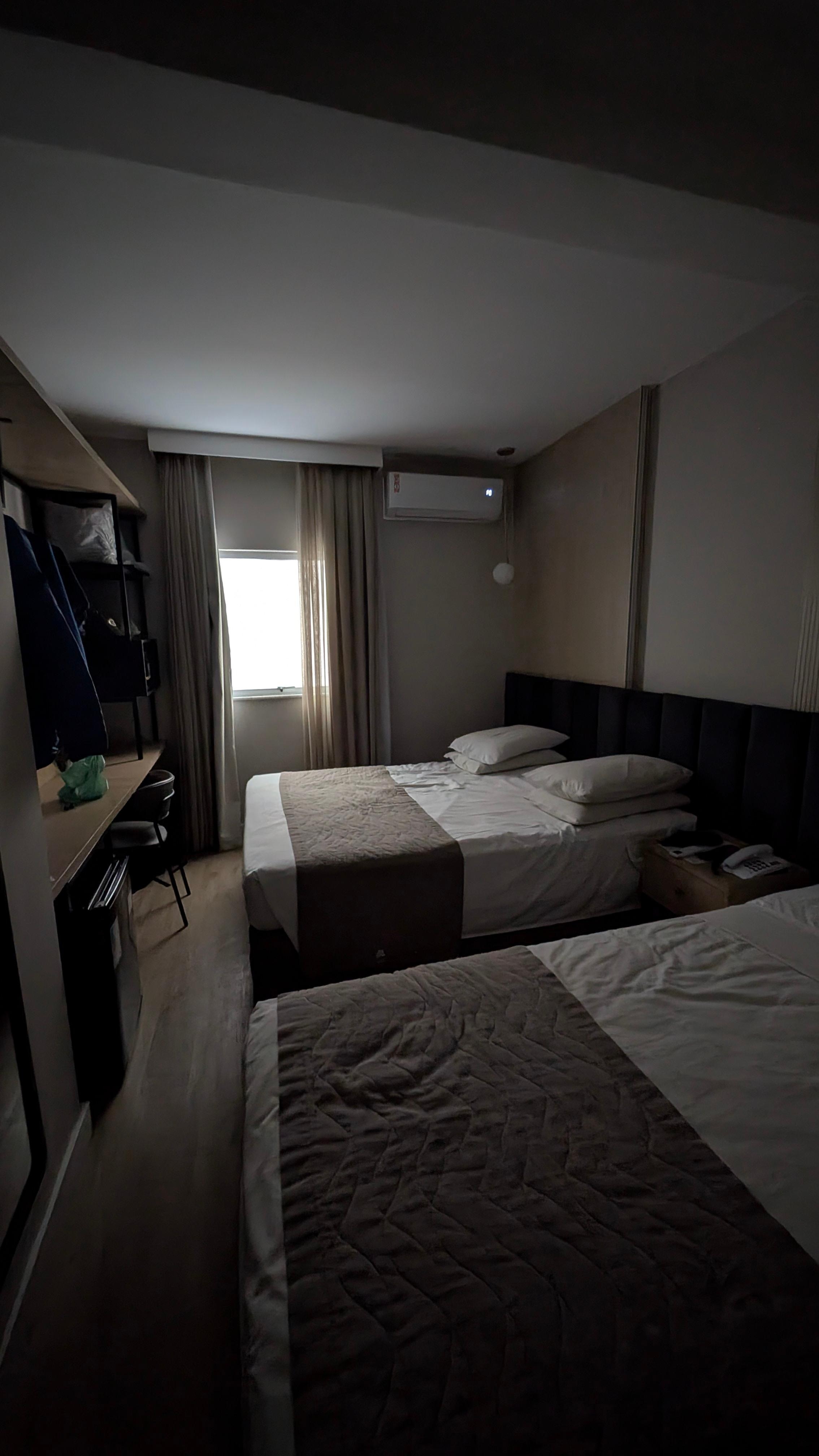 First room 119, dark with concrete building wall view at the window