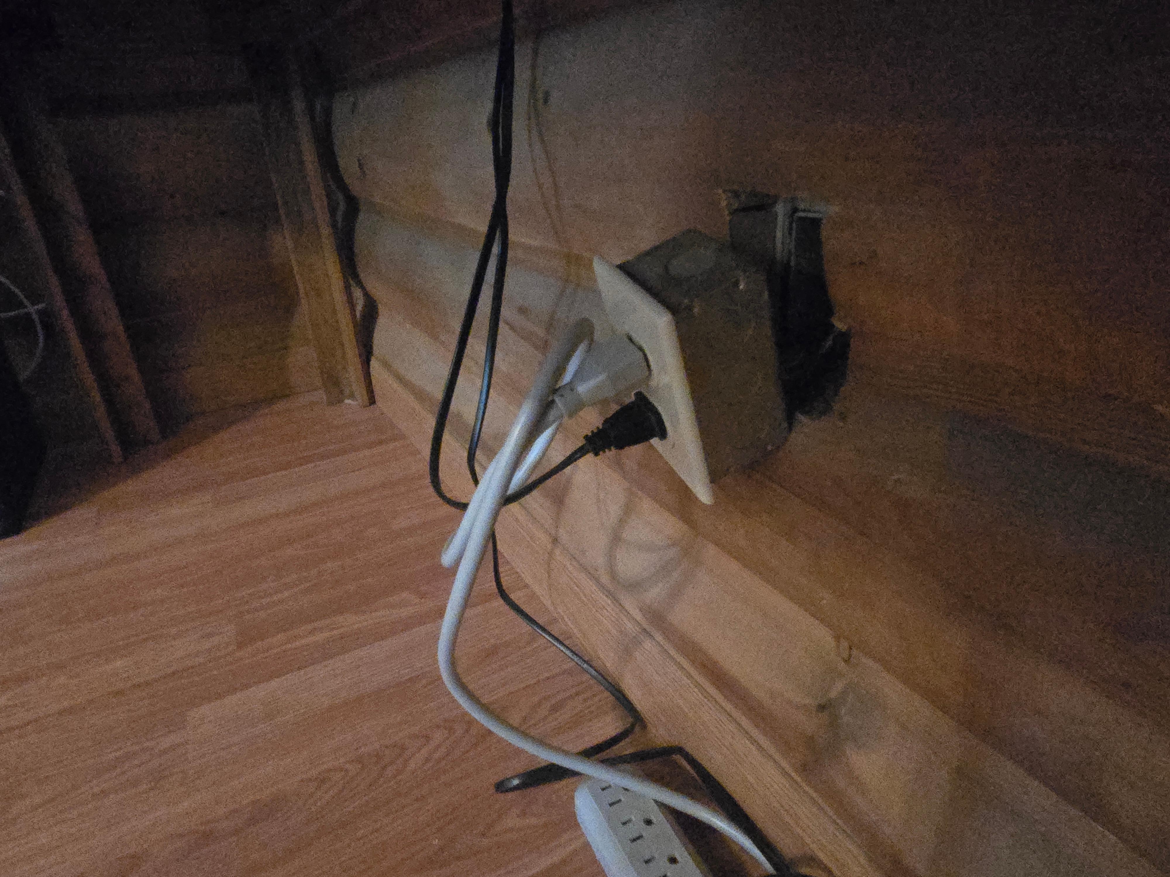 Exposed wires behind electrical outlet