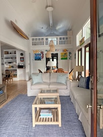 Behind the sofa is a large dining table and to the left is an additional breakfast table for additional seating.