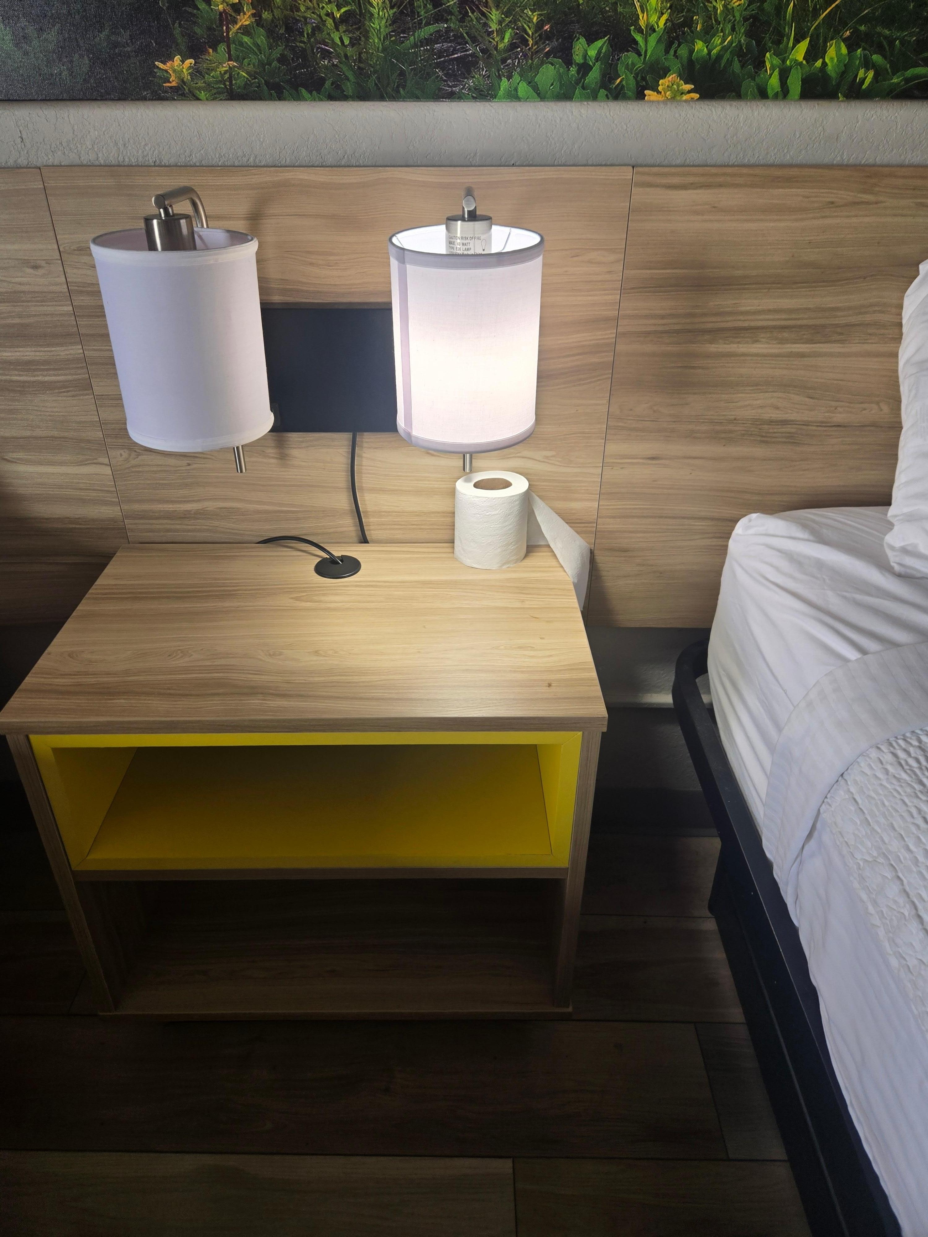 A half used roll of toilet paper was left on the night stand 