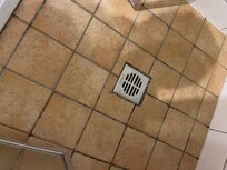 Verschimmelte, ausgewaschene Fugen im Boden der Dusche