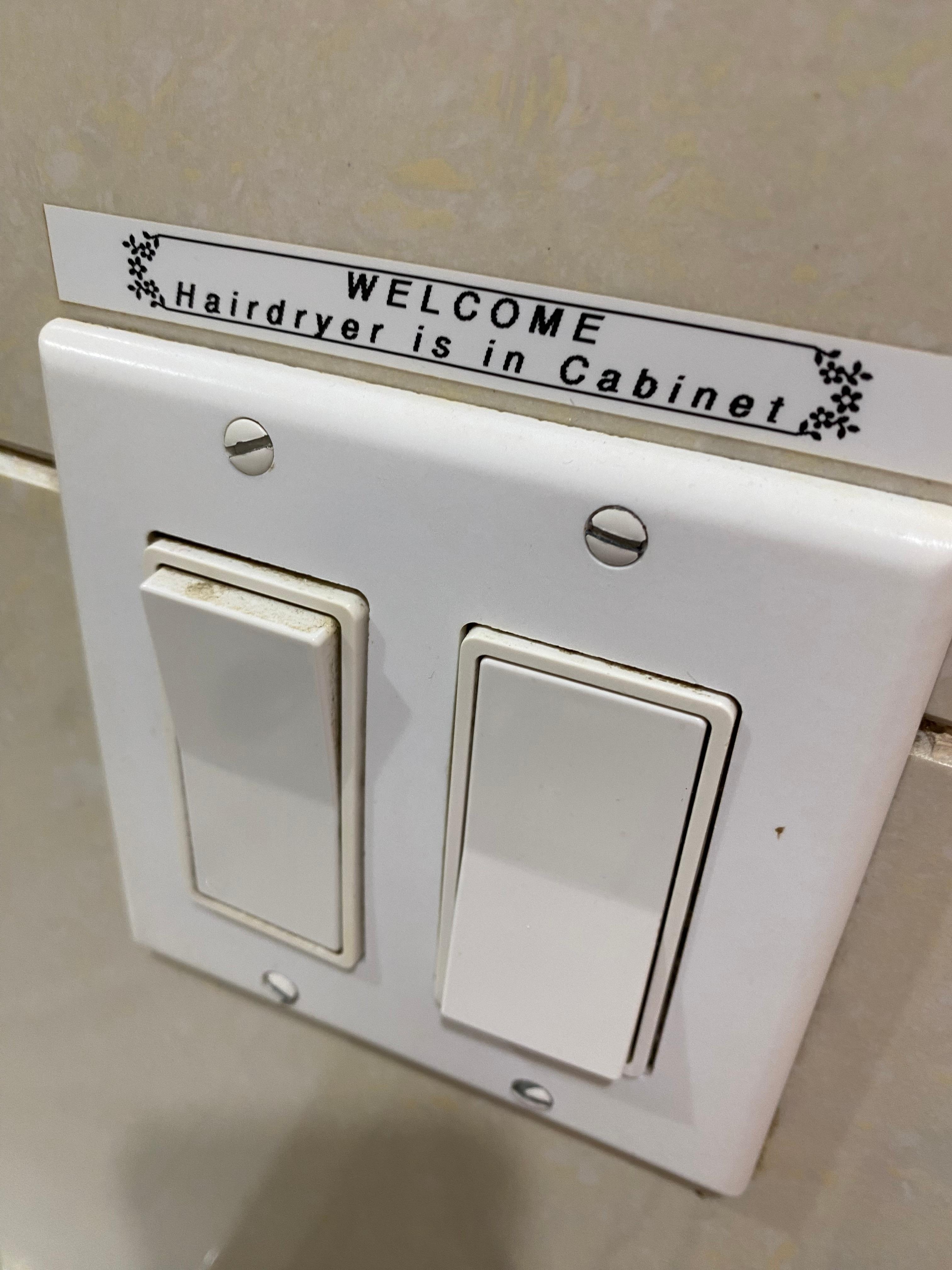 Dirty light switch that says where the hair drier is...
