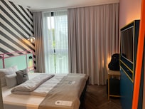 Gemütliches Zimmer mit mehreren Kissen, Bluetooth-Lautsprecher und Fernseher, den man mit Handy oder Computer verbinden kann
