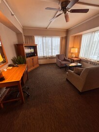 Seating room with couch, chair, desk and hosting table.