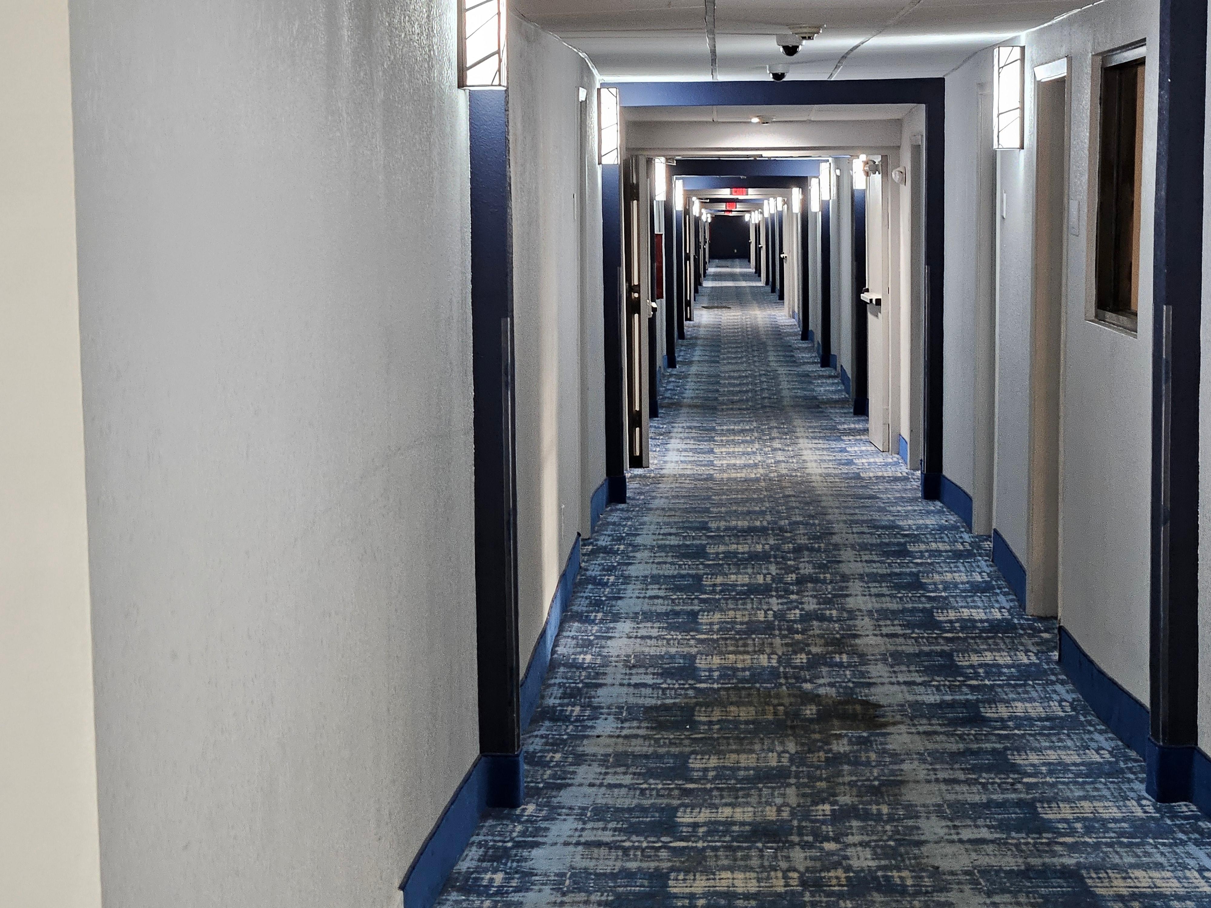 An extremely long hallway, with undulating floor, and no steps as the floor elevation changes.