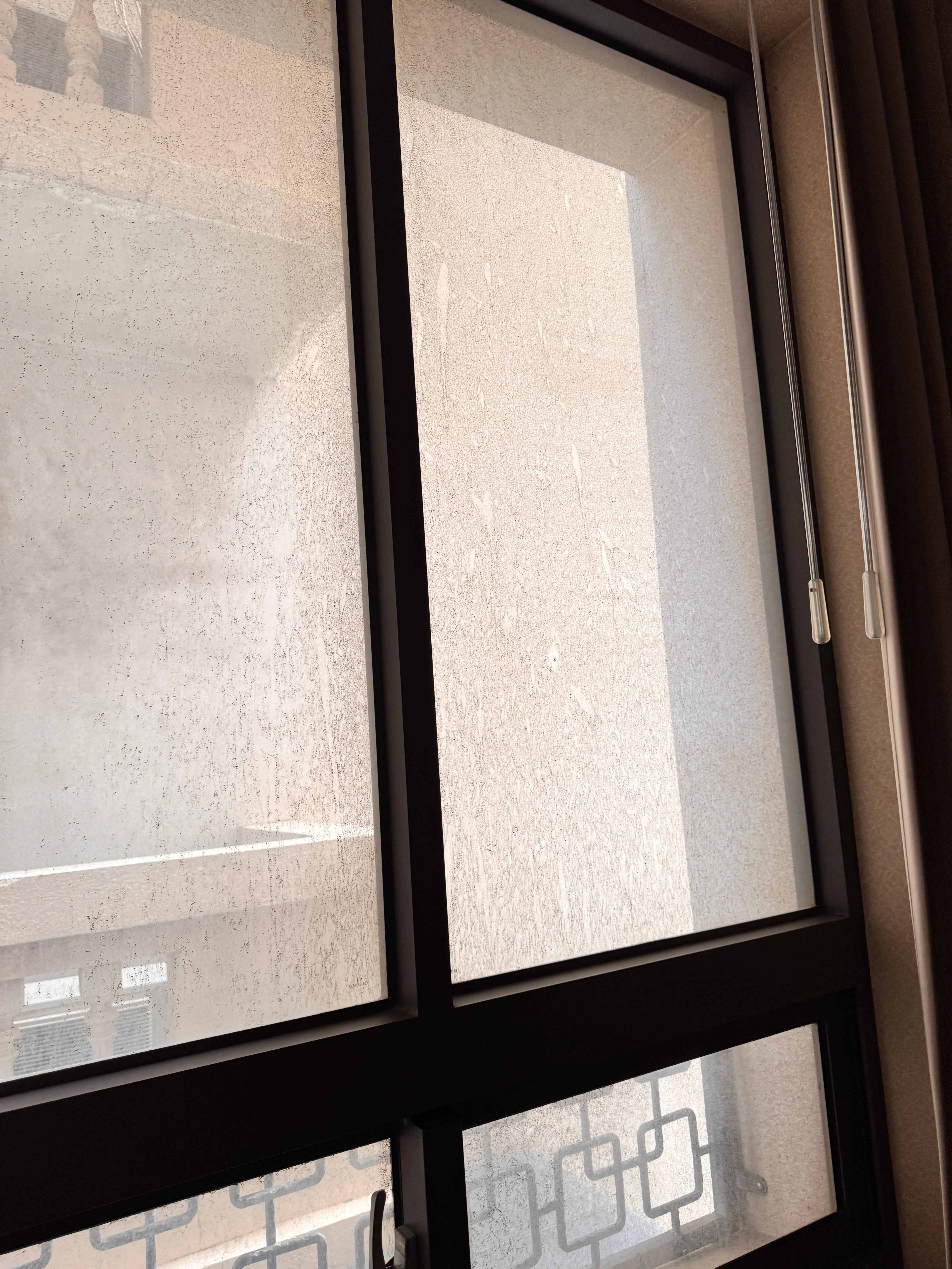 唯一採光的窗戶是髒污黑麻麻的玻璃，望出去是牆壁