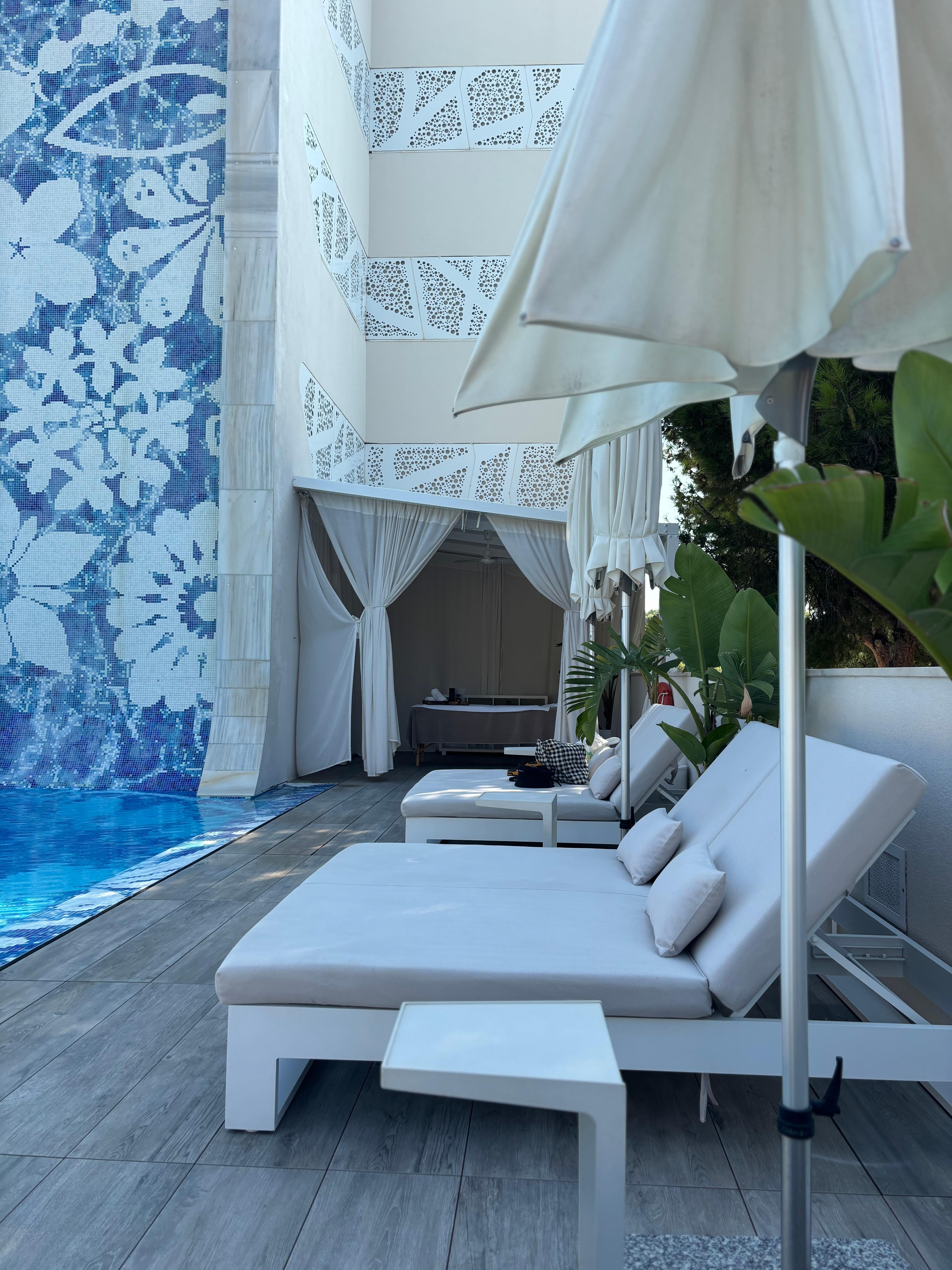 Sköna lounge bäddar och solstolar vid poolen