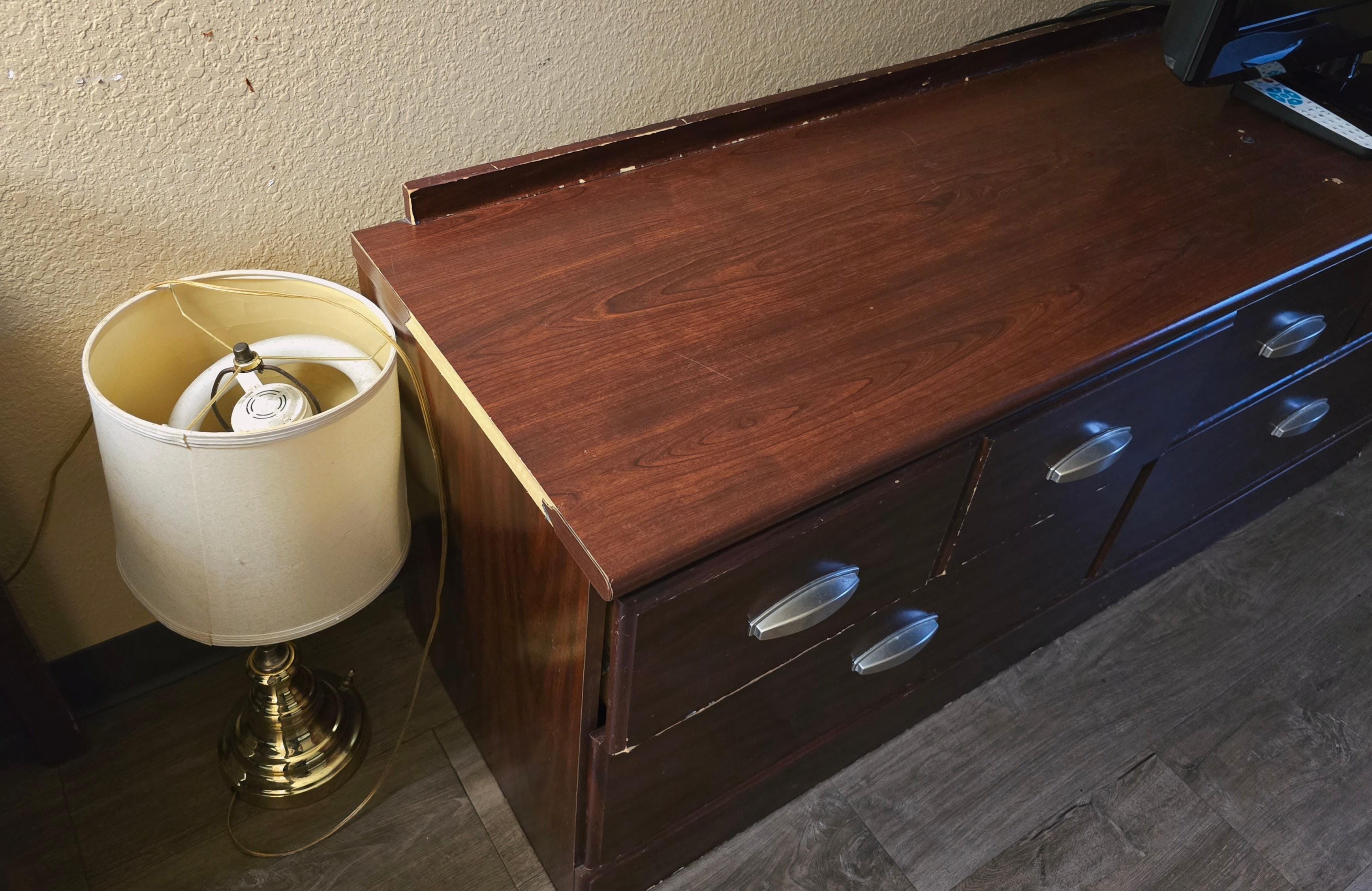 Random lamp on the floor next to the shoddy dresser 