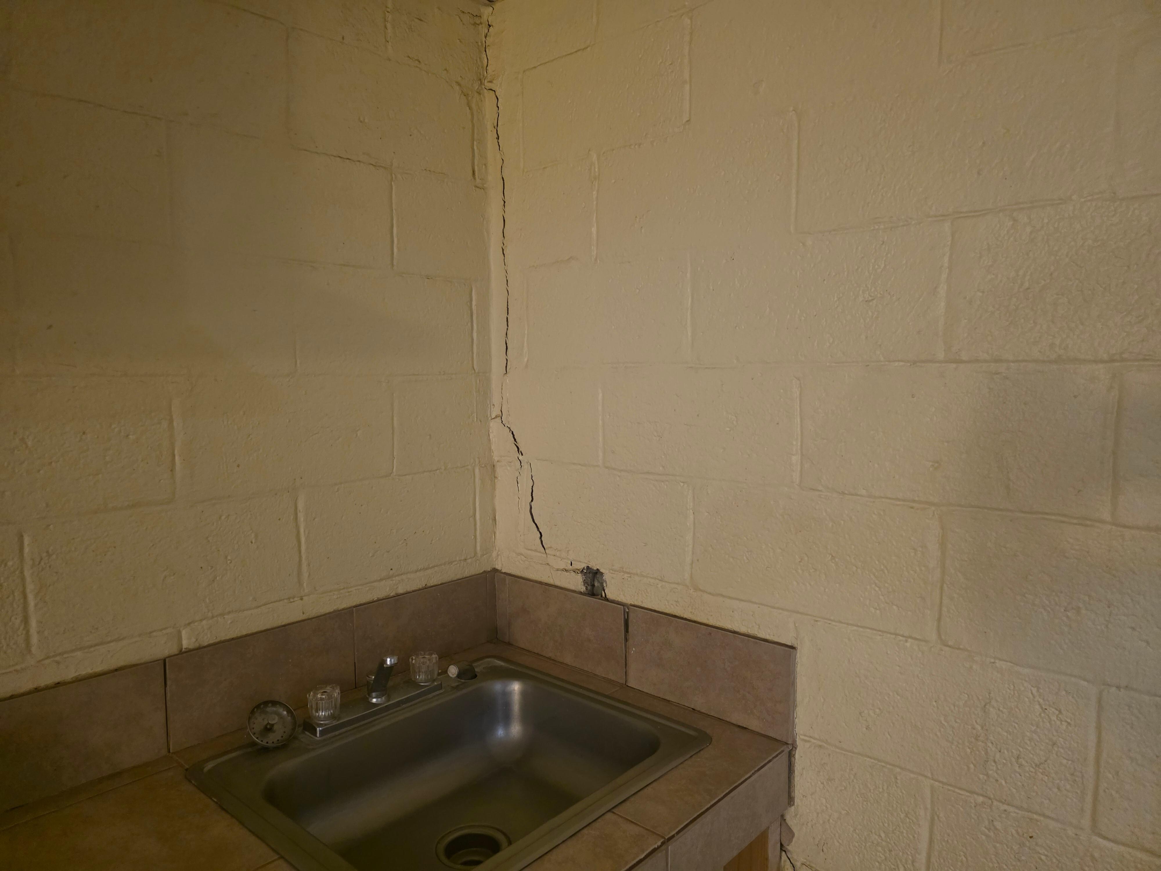 Cracked walls where the cockroaches hid after we entered the room.