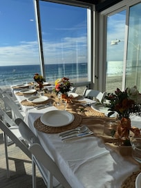 Table set in living room for Thanksgiving dinner with all guests having a spectacular view of the ocean.
