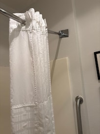 The shower curtain rod was falling out of the wall.