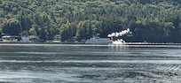 Steamboat passing by seen from resort with zoomed camera