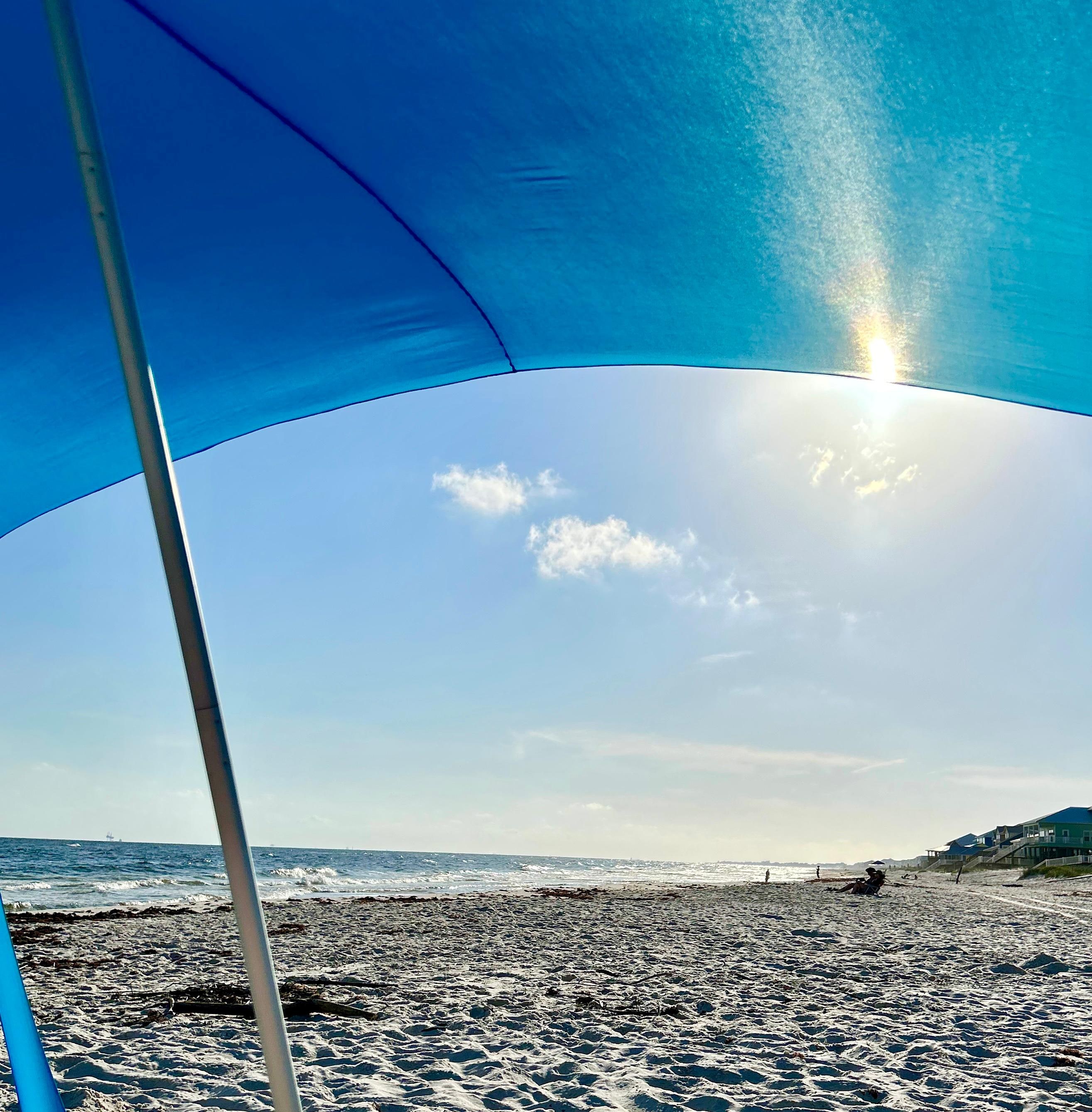 Sitting under the provided beach canopy. 