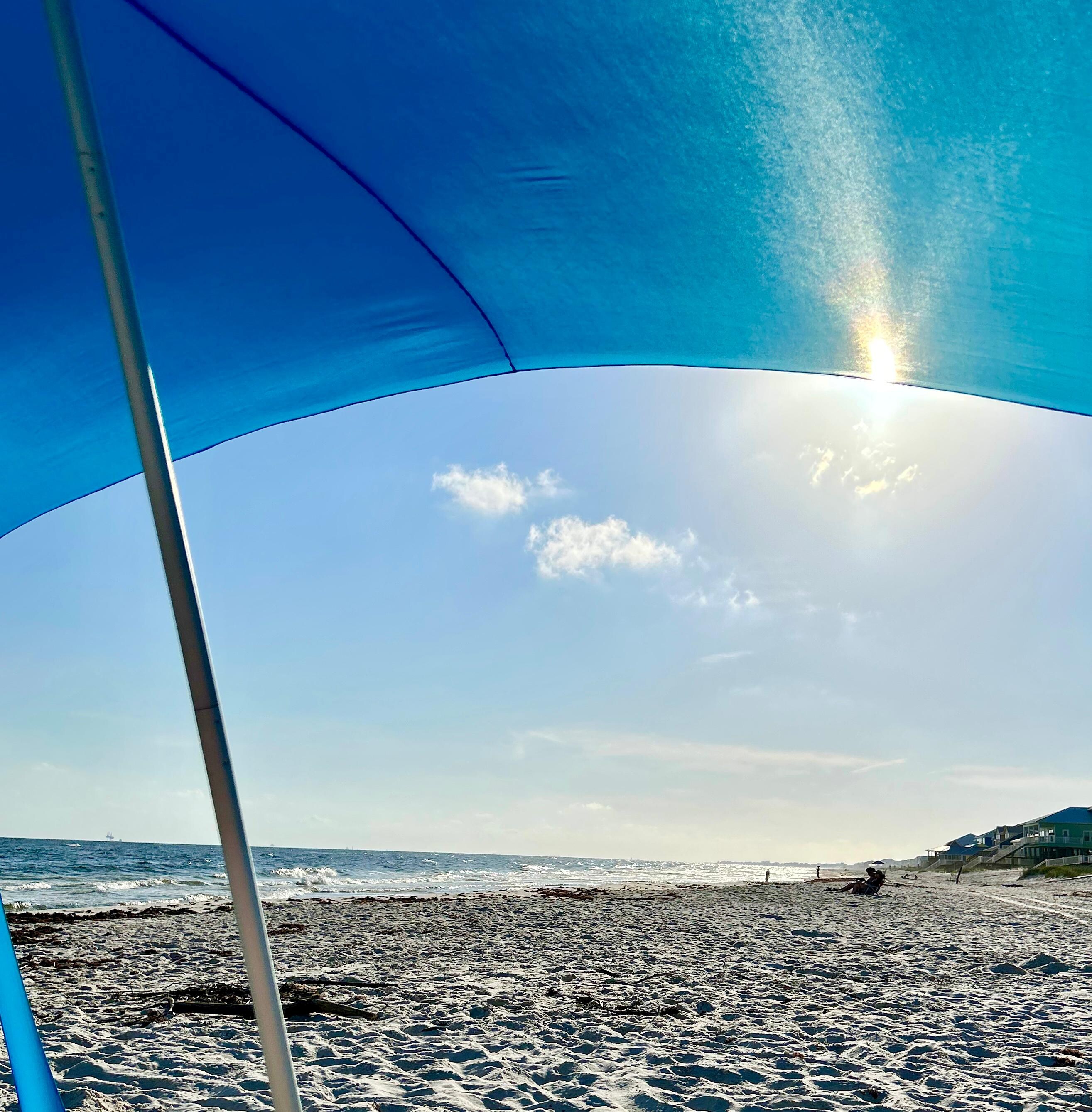 Sitting under the provided beach canopy. 