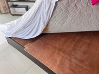 Very old mattress with cheap bed covered with plywood