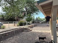 Expansive fenced front yard, with gate leading from parking and a path to the front door.