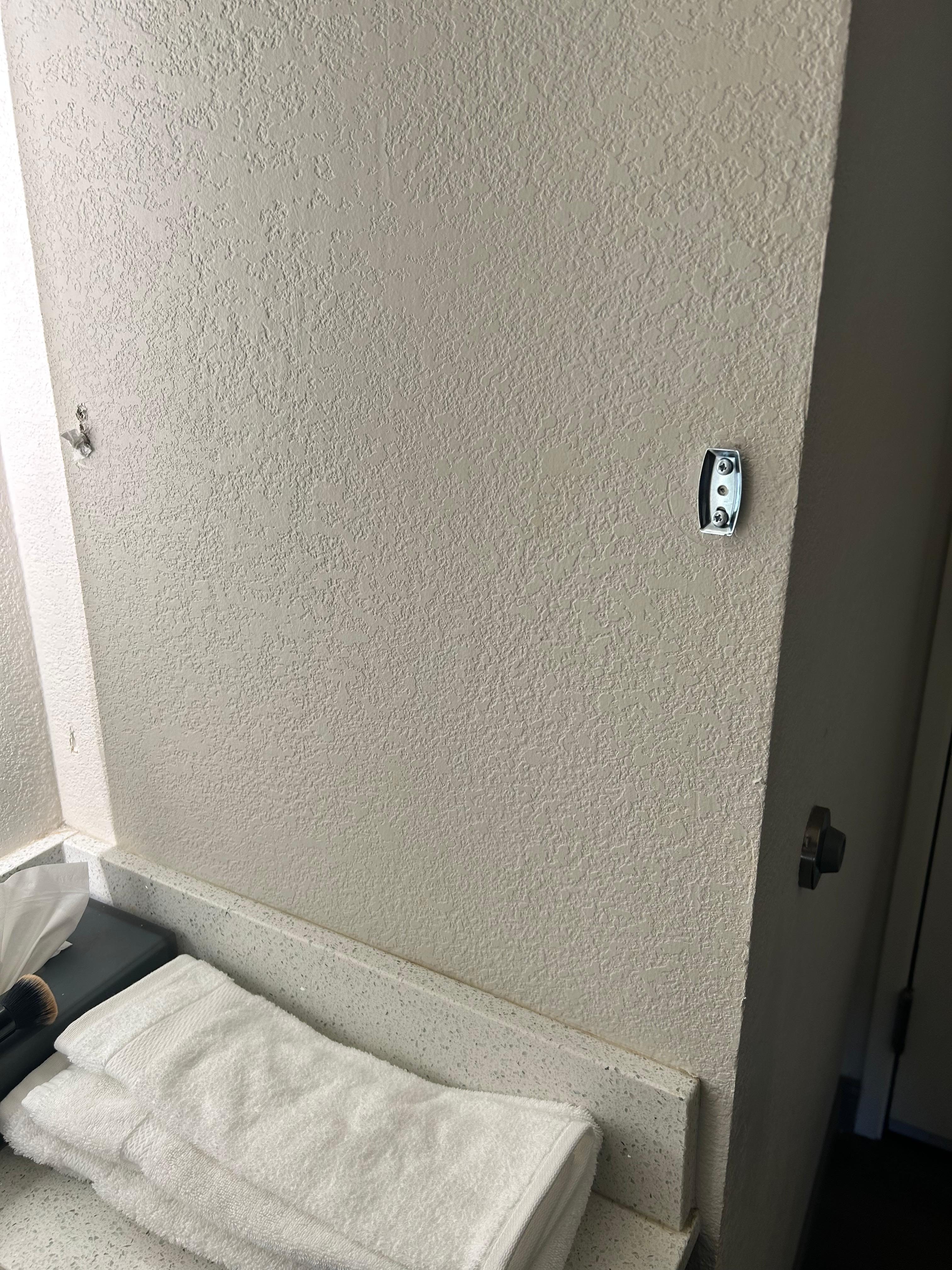 I think this used to be a towel rack since the towels were placed on the counter…? Some of the hardware is still on the wall. Replace the rack or remove the hardware and patch the holes