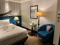 ROOM with interior window. Bedroom, has an armchair, small table, lamp and bed seat