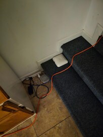 Bunches of cords for internet and a/c unit on steps from hallway to master.