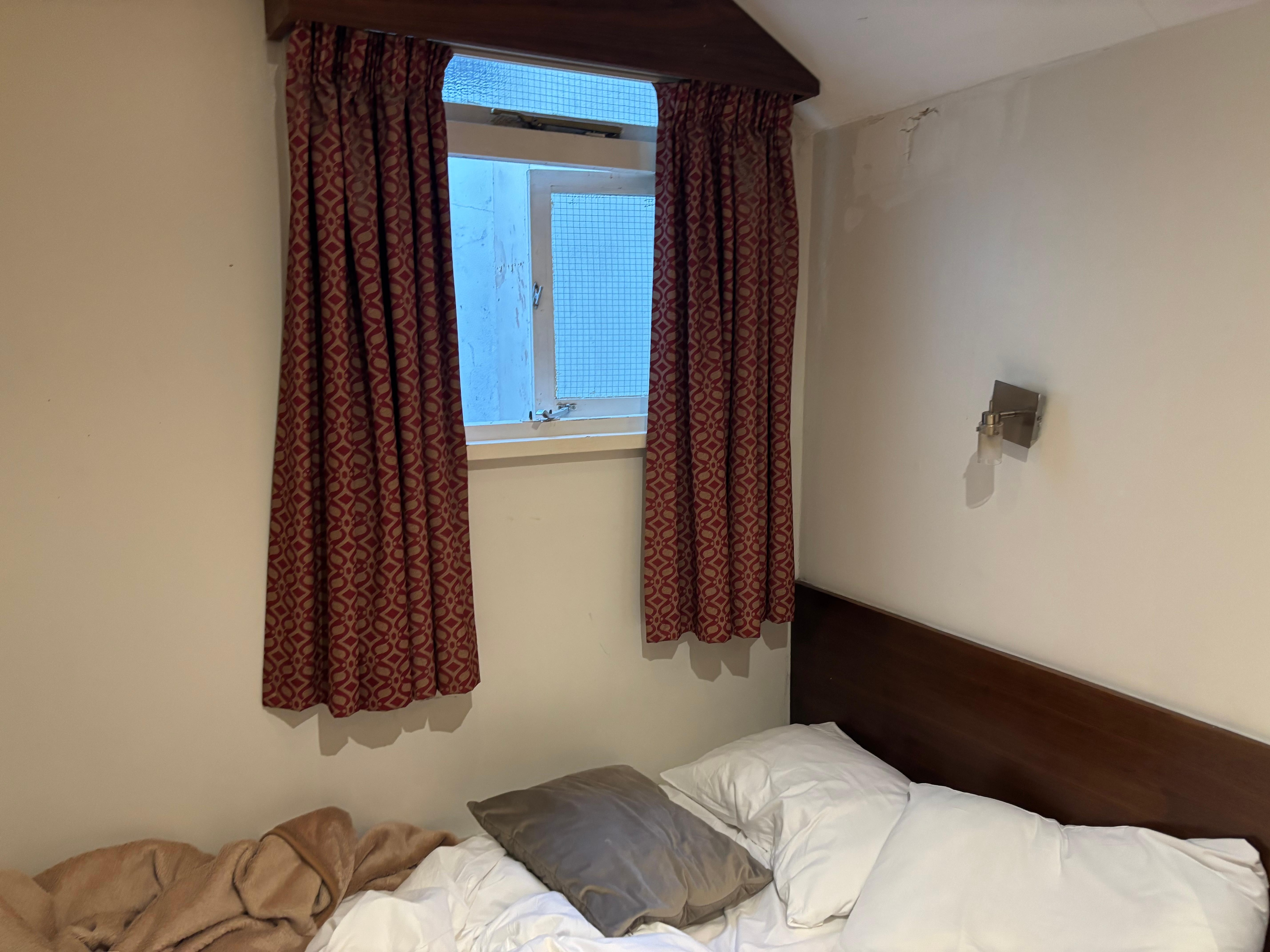 This tiny window in the basement led to a shack, so not outside. The bed were slightly wider than that single bed with one cover and one light, so actually a single bed. 