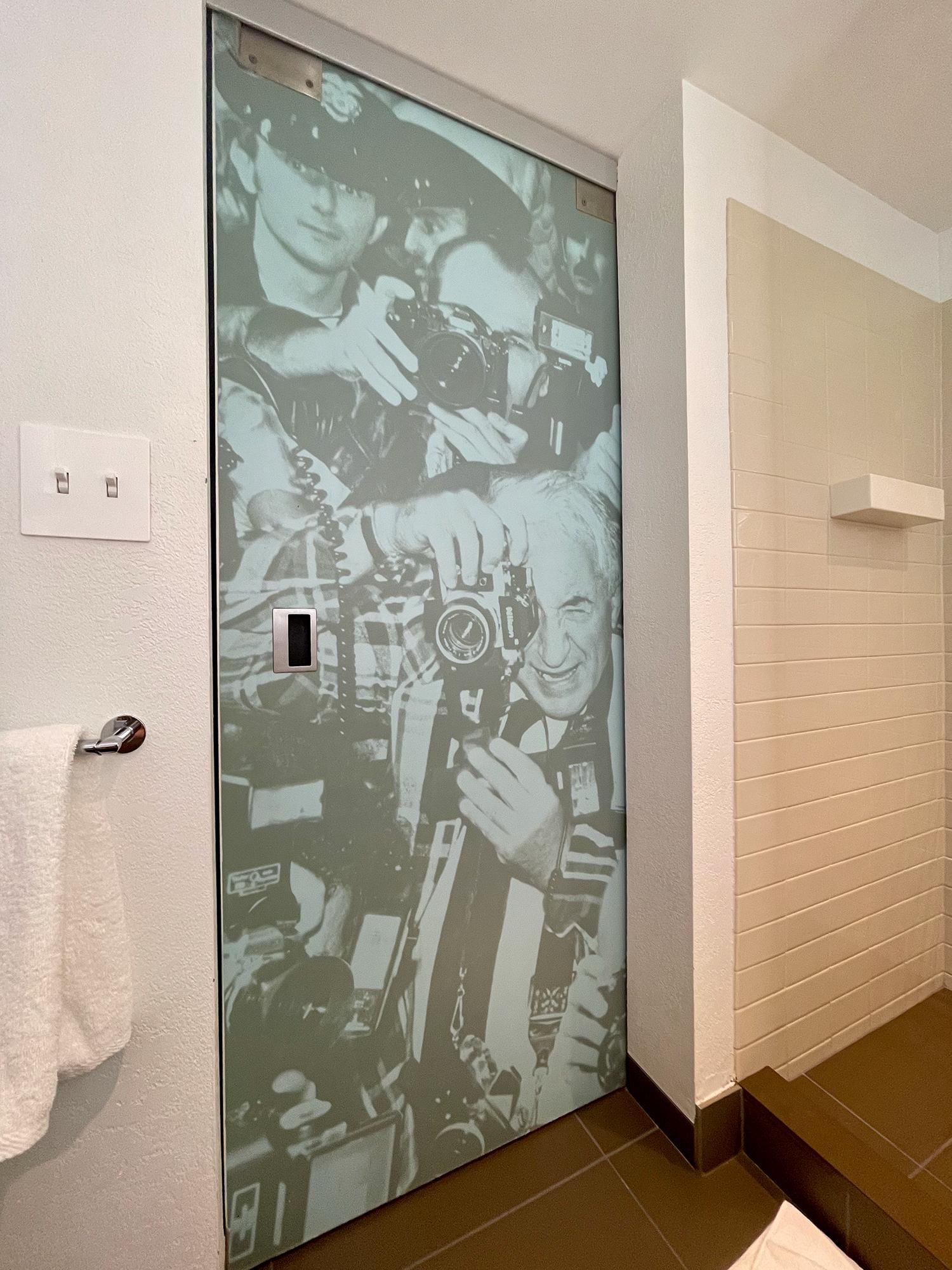 The inside door of the bathroom has this great detail of photographer at a 20th Century rock concert. They are looking at you.