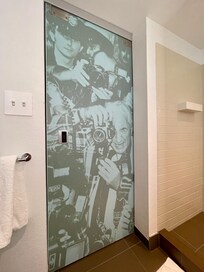 The inside door of the bathroom has this great detail of photographer at a 20th Century rock concert. They are looking at you.