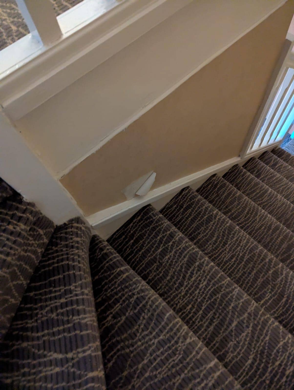 Ripped wallpaper on stairs up to mezzanine, with stairs that were extremely uneven