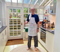 Happy husband in the kitchen making breakfast.