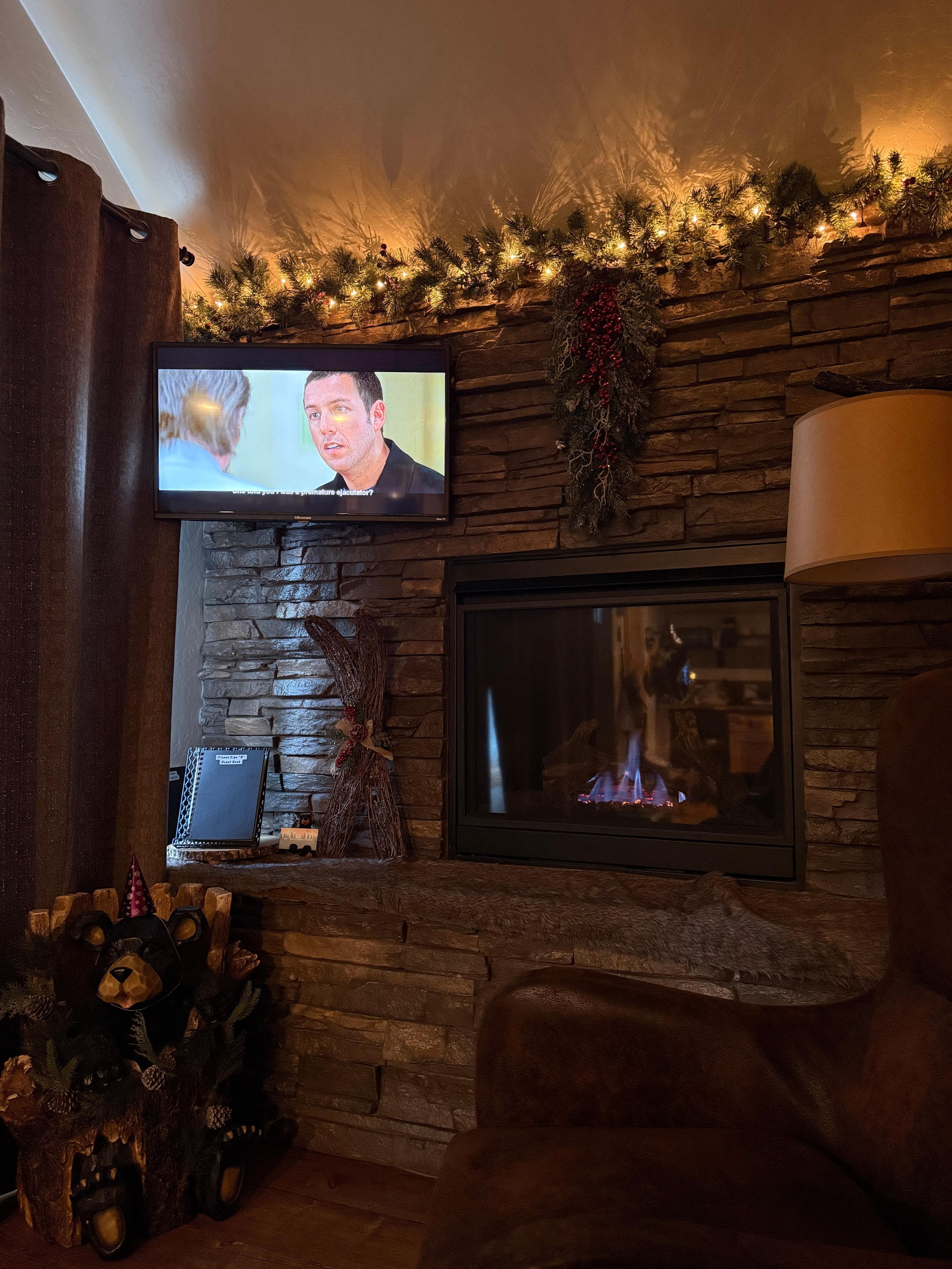 Movies and warmth next to fire place in living room area 