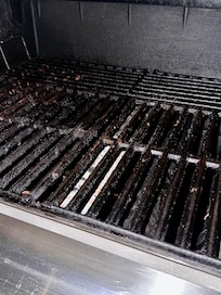 Fully loaded grease inside grill. Fire extinguisher underneath grill was empty. Broken glass across rocks outside of this.