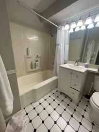Bathroom with tub and detachable showerhead.