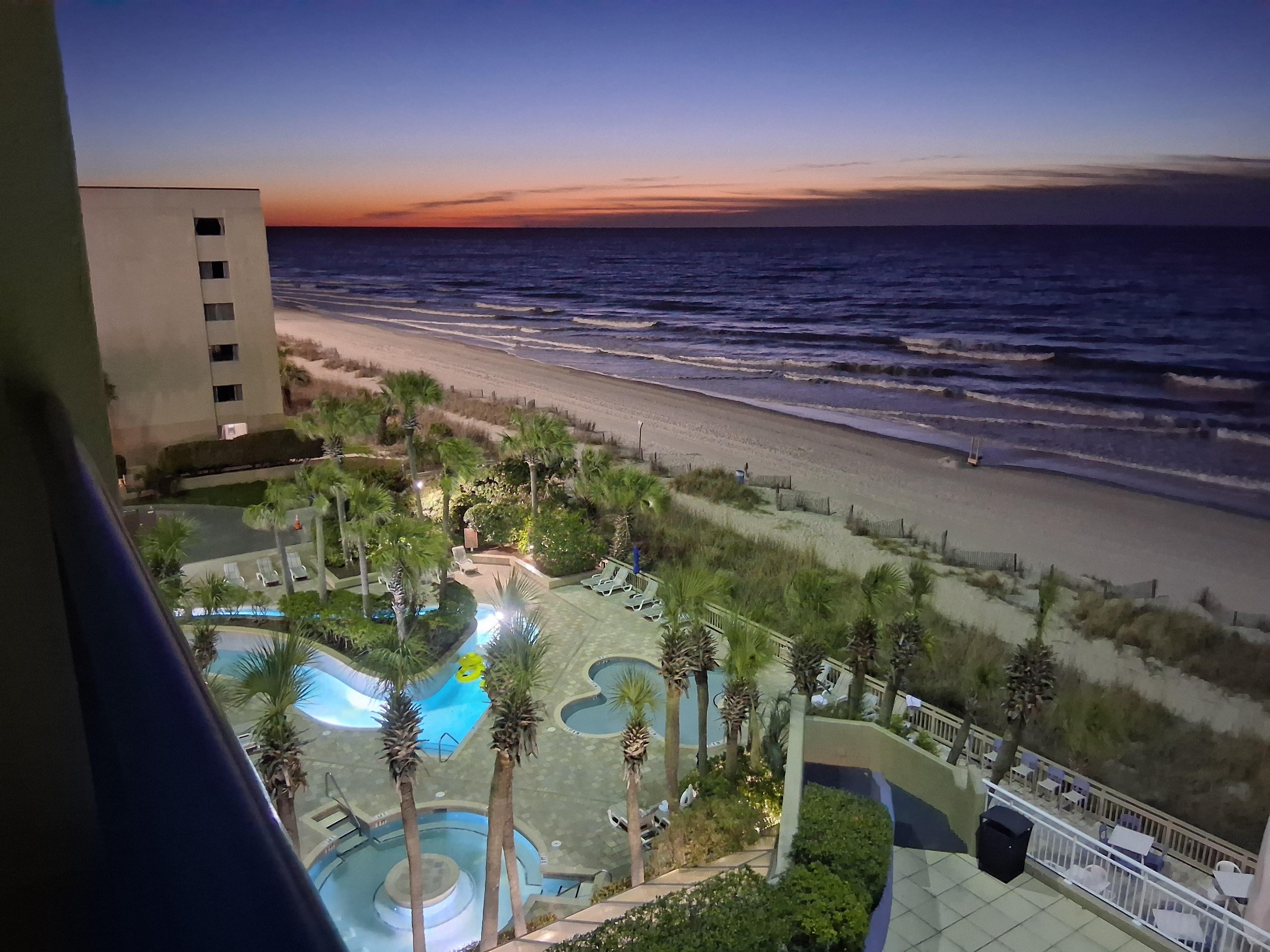 Sunrise from 5th floor 3-18-26. The pool lazy river is at the Resort.