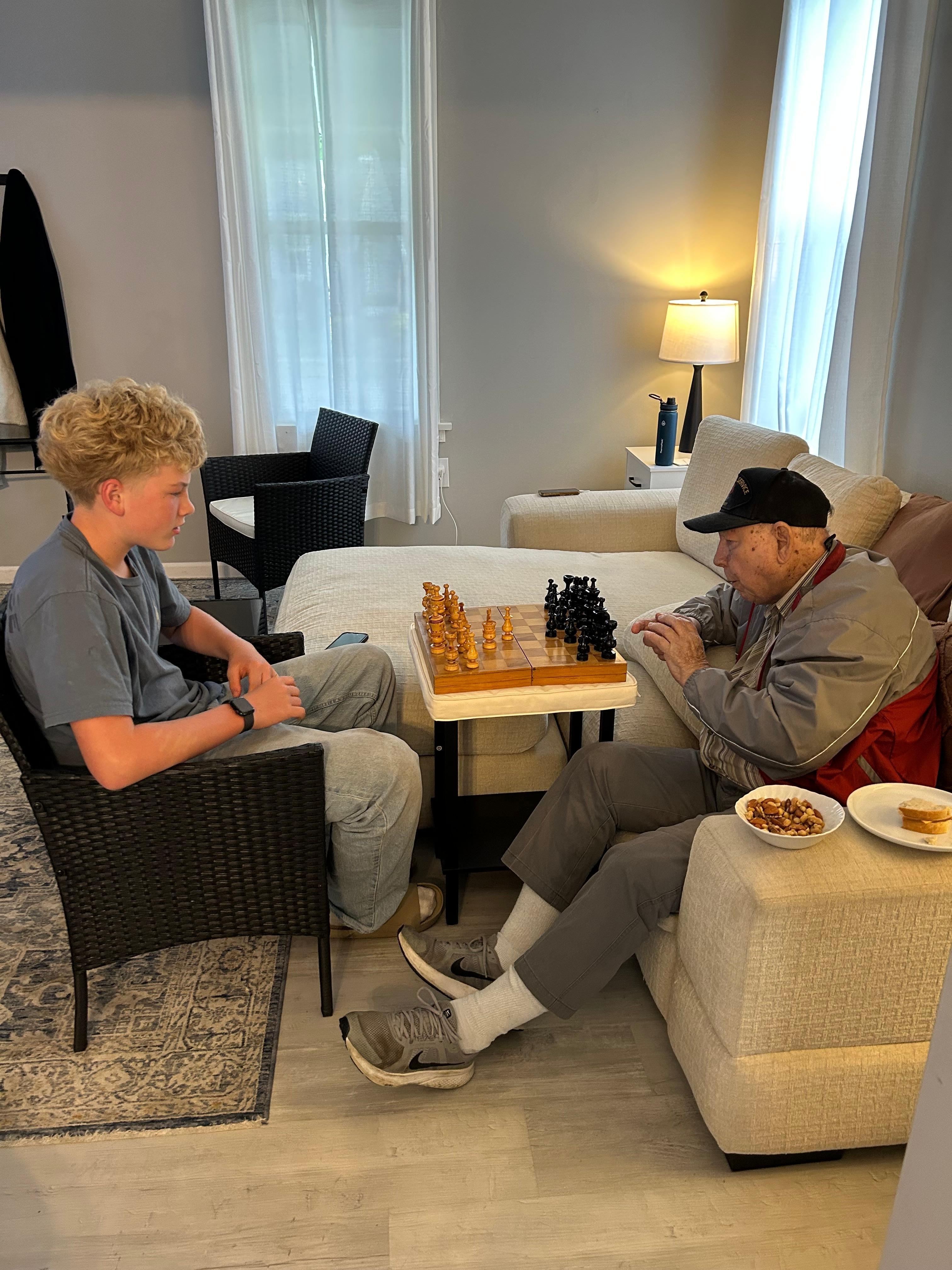 Great grandpa playing chess with his great grandson.
