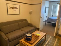 Living room with its own tv, also a coffee bar and a refrigerator, couch has a pullout bed